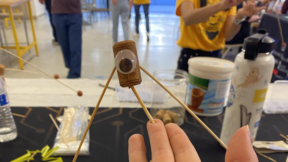 Balancing buddy is balancing on a finger, demonstrating center of mass