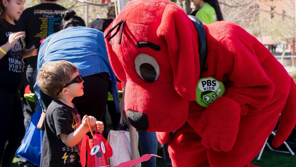 Clifford the Big Red Dog greets a child.